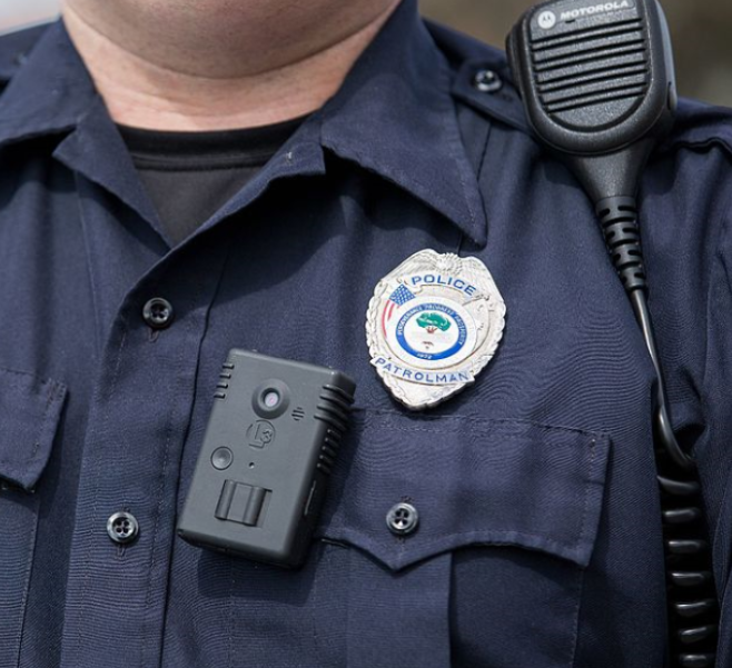 Police officer with a plain sight body camera on his shirt.