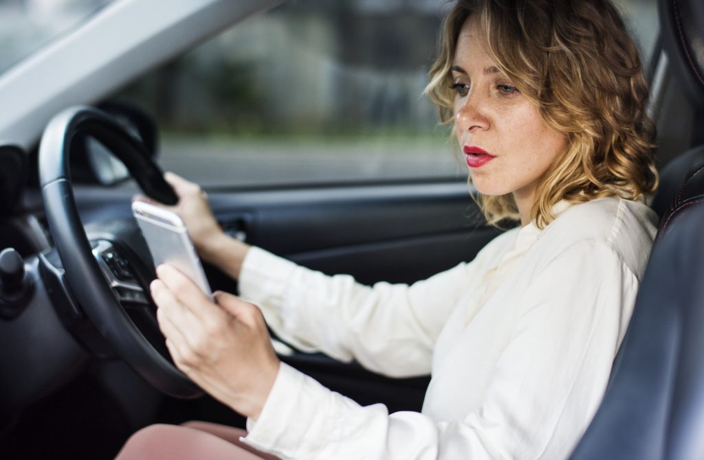 Woman using mobile phone while driving - safe driving laws