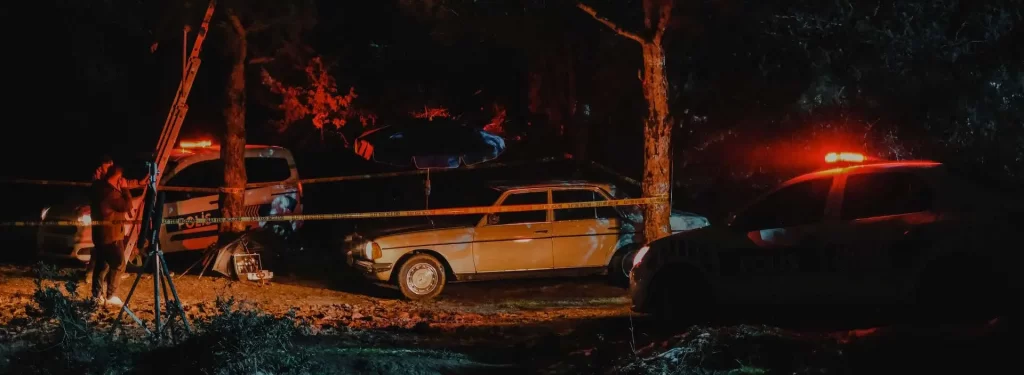 Vehicle surrounded by yellow investigation tape at night